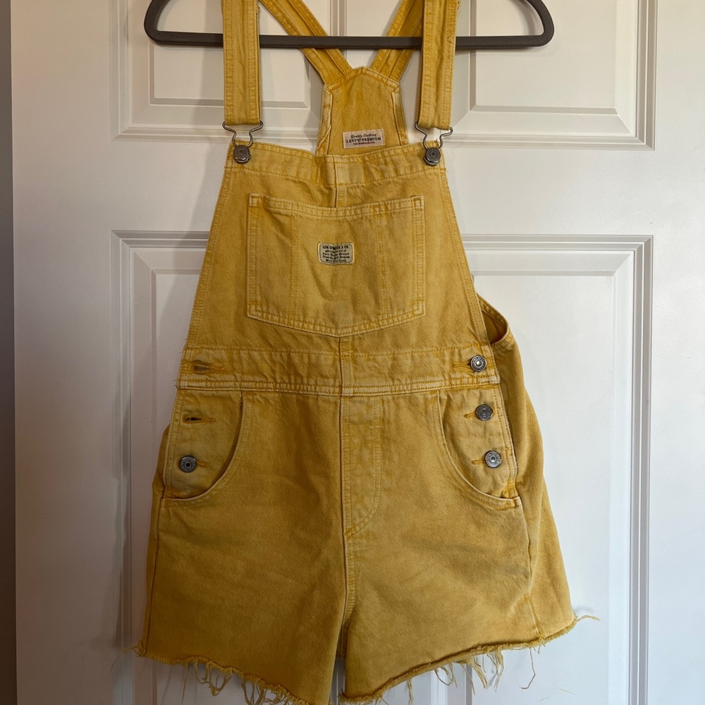 Yellow Levi’s short overalls.
